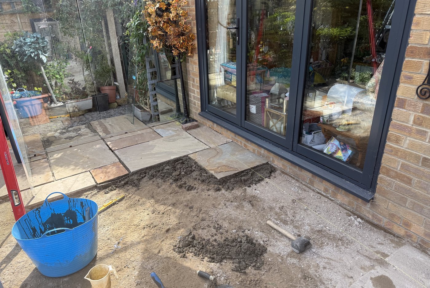 Sandstone patio before works — uneven and edge failure